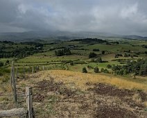 Paysage agricole depuis Combegrasse. Au fond sous les nuages les puys d'Augère (1243m) et de Combe-Perret (1380m)