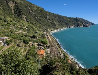 L'environnement de Corniglia. Voie ferrée, terrasses plantées de vigne et au fond, sur la pointe, le village de Manarola