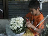 Un jeune garçon au travail dans le marché aux fleurs de Bangkok